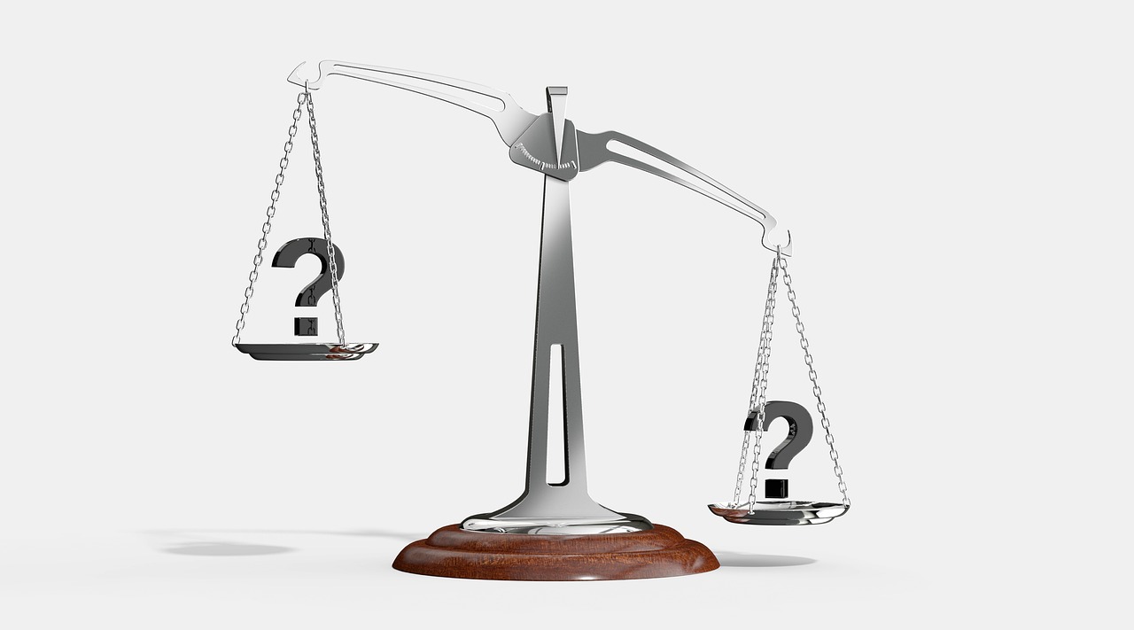 A classic balance scale weighing a stack of coins against a percentage symbol on paper.