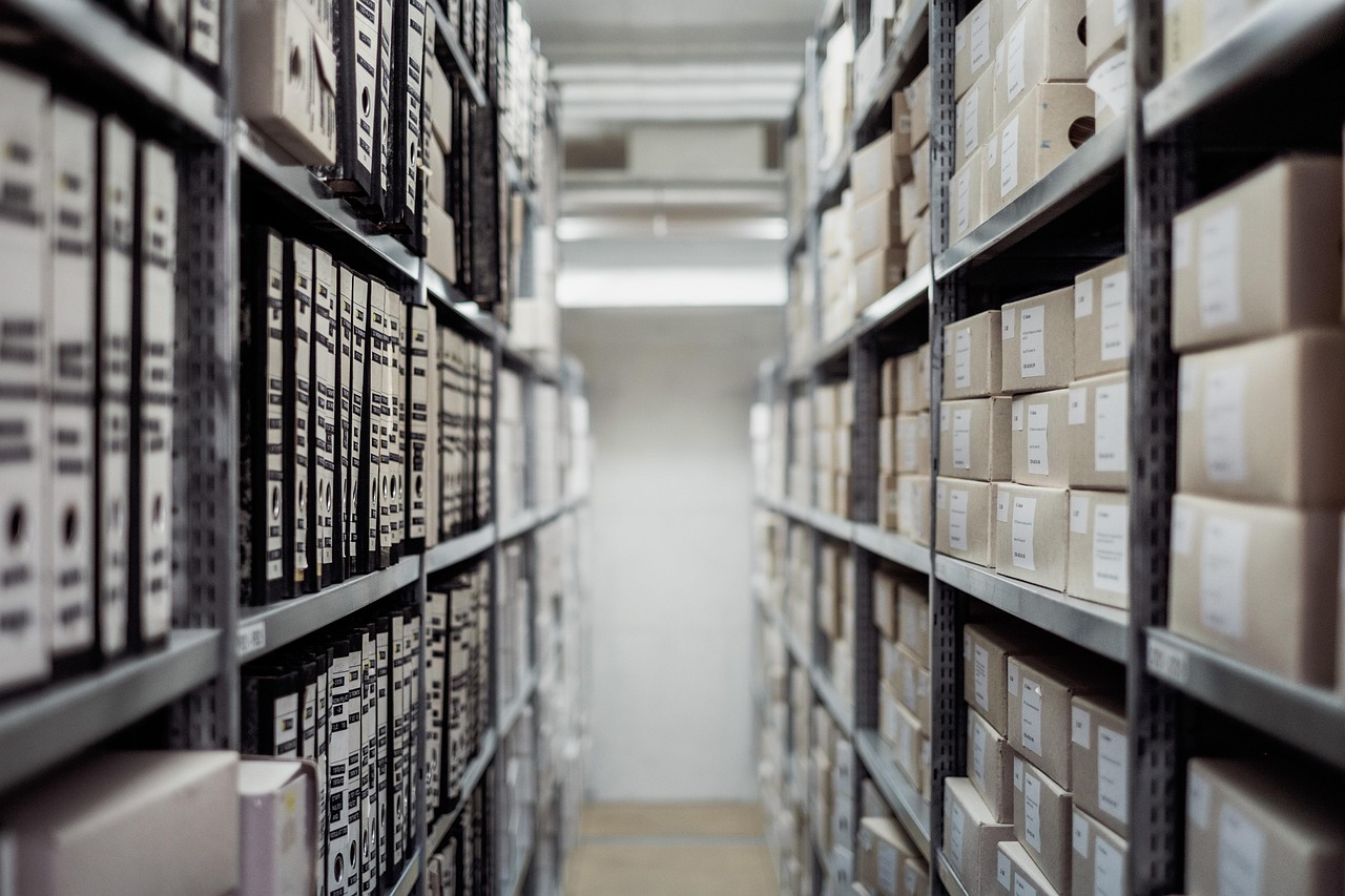 Organized blue file folders sitting on an office shelf representing documentation storage.