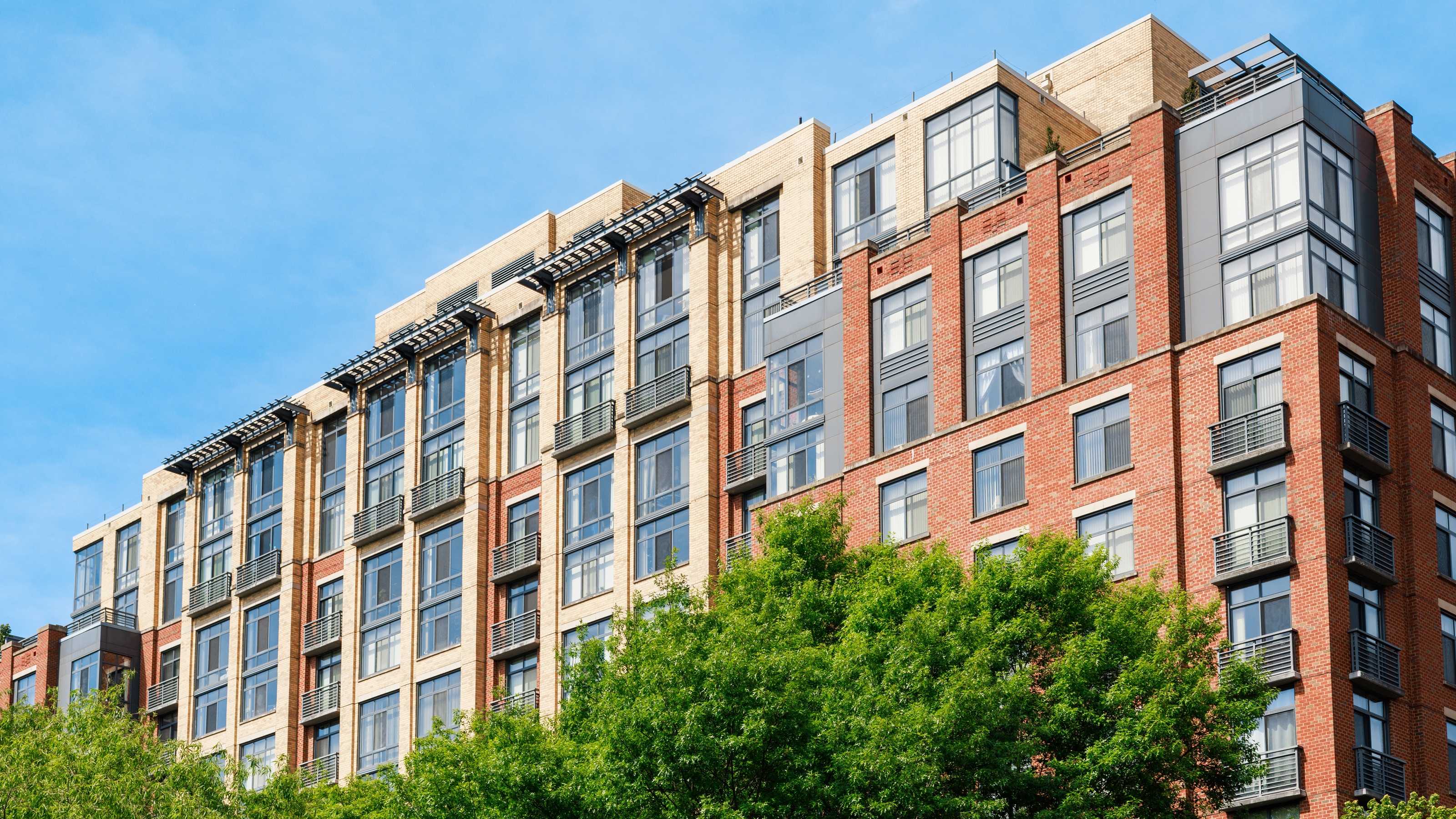 Modern sunny multifamily apartment building representing a high-yield commercial real estate asset.