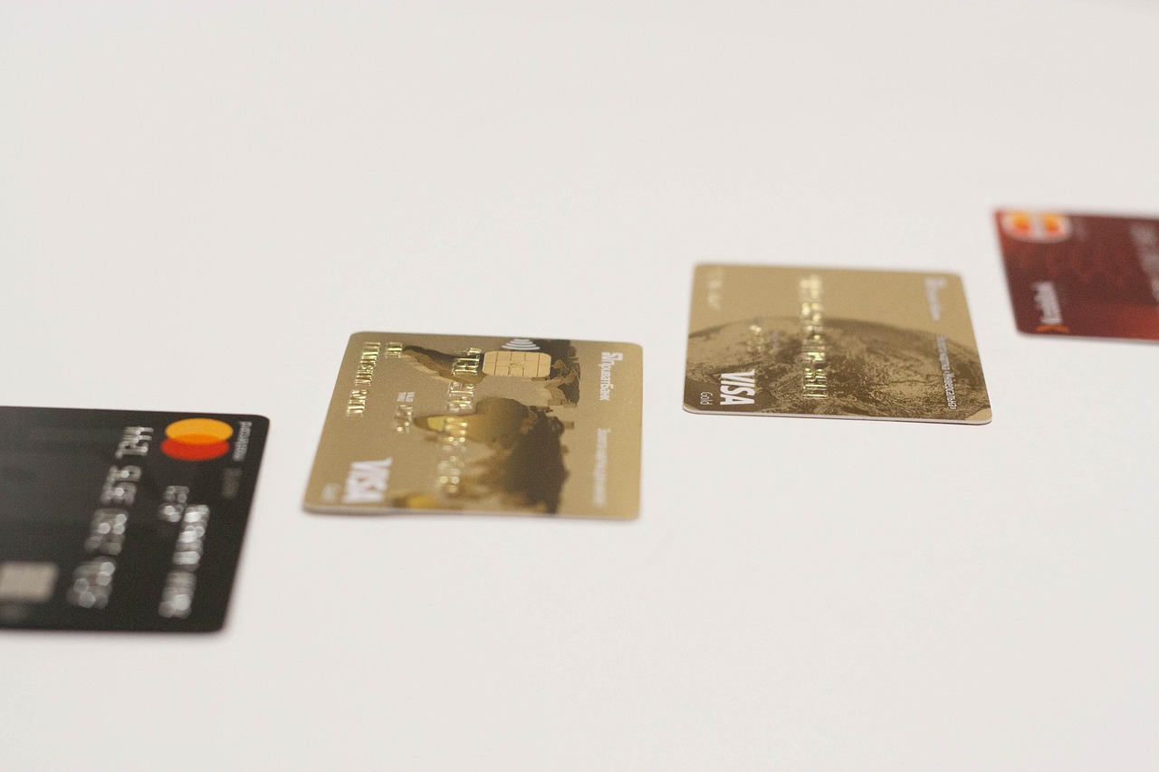 A car key and a credit card side-by-side on a wooden surface.