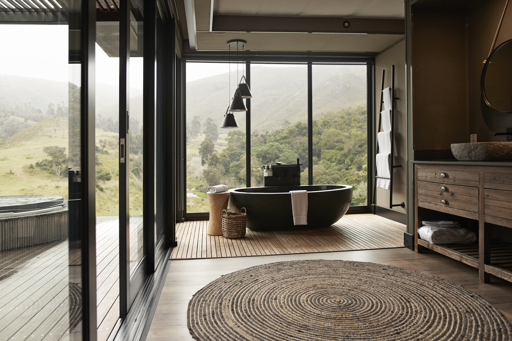 Interior of a modern luxury bathroom featuring a designer pendant light over a soaking tub.