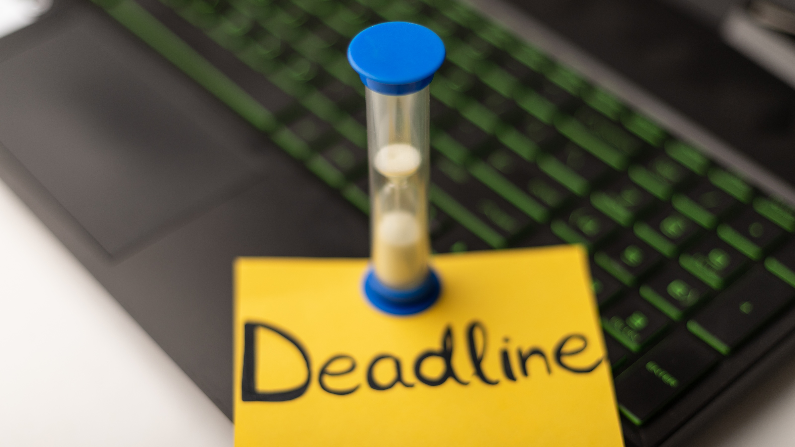 A minute timer on a sticky note reading 'deadline' placed on a laptop keyboard.