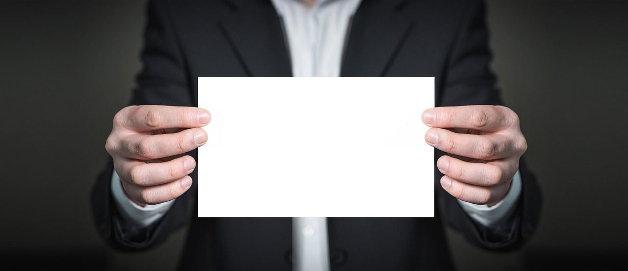 A professional in a suit holding a credit card, emphasizing the start of a cardholder relationship.