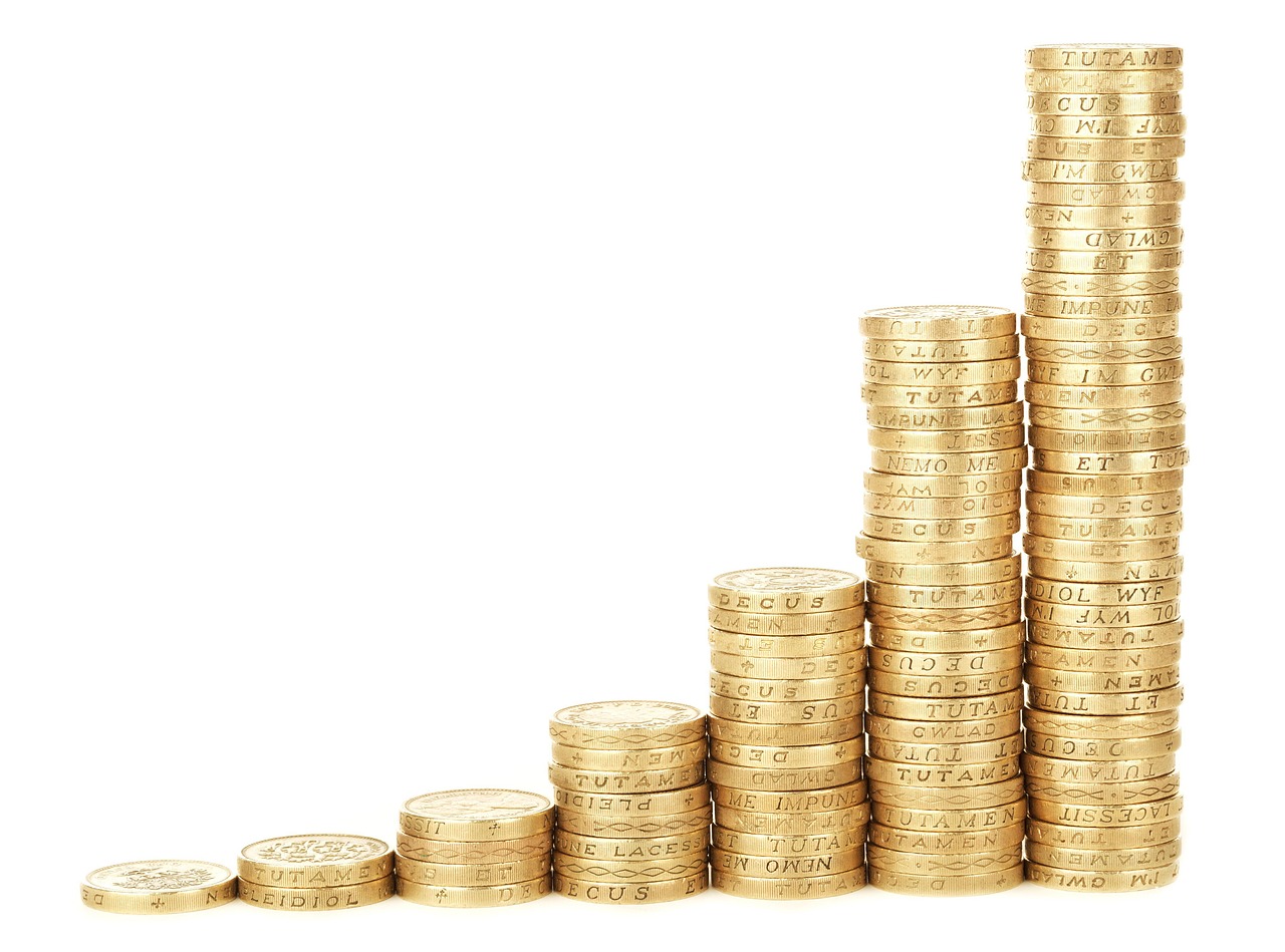 Stacks of coins increasing in height next to a graph, representing financial scaling.