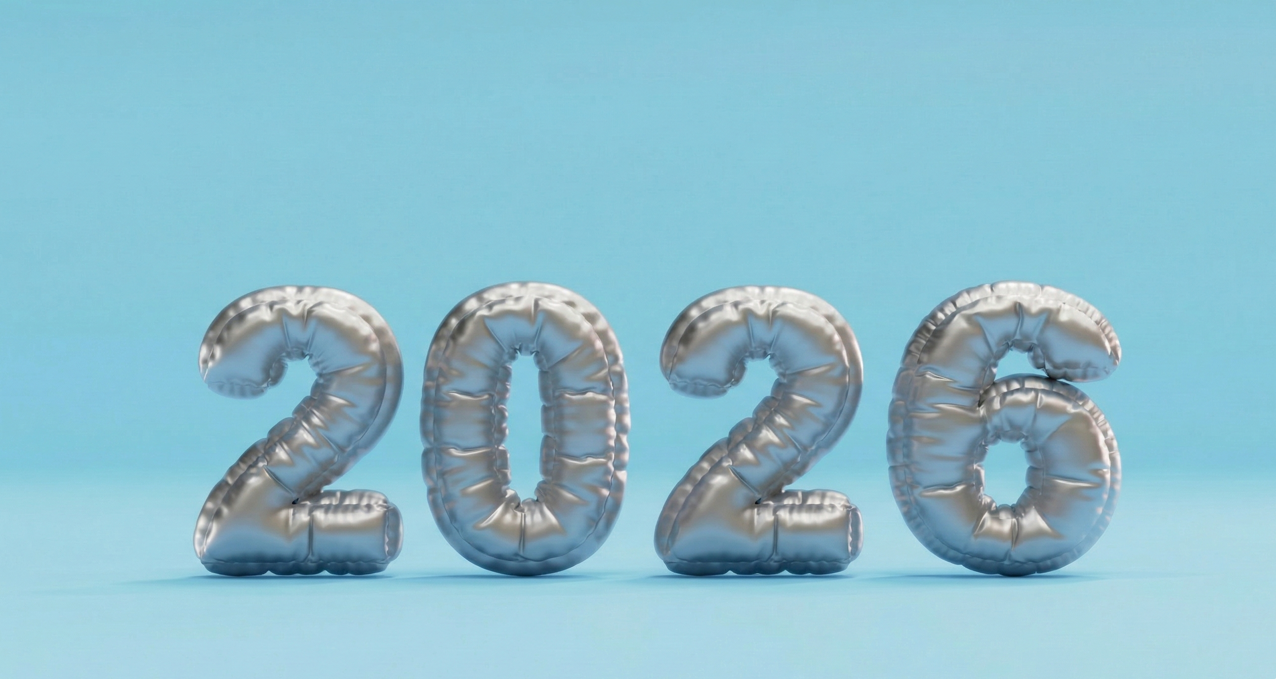 Decorative silver foil balloons forming the year 2026 against a blue background.
