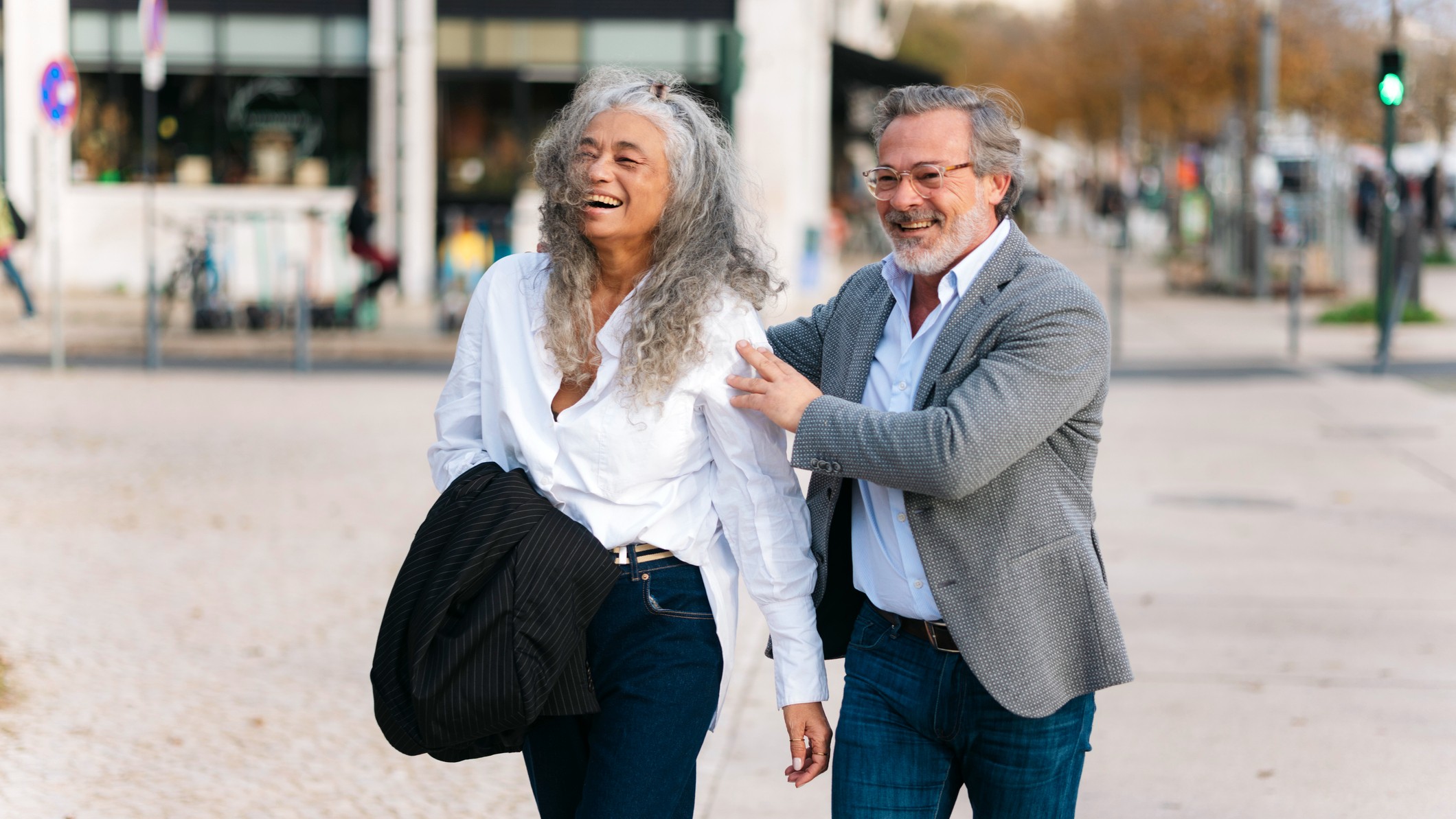 A happy senior couple walking together while exploring a new city during their retirement travels.