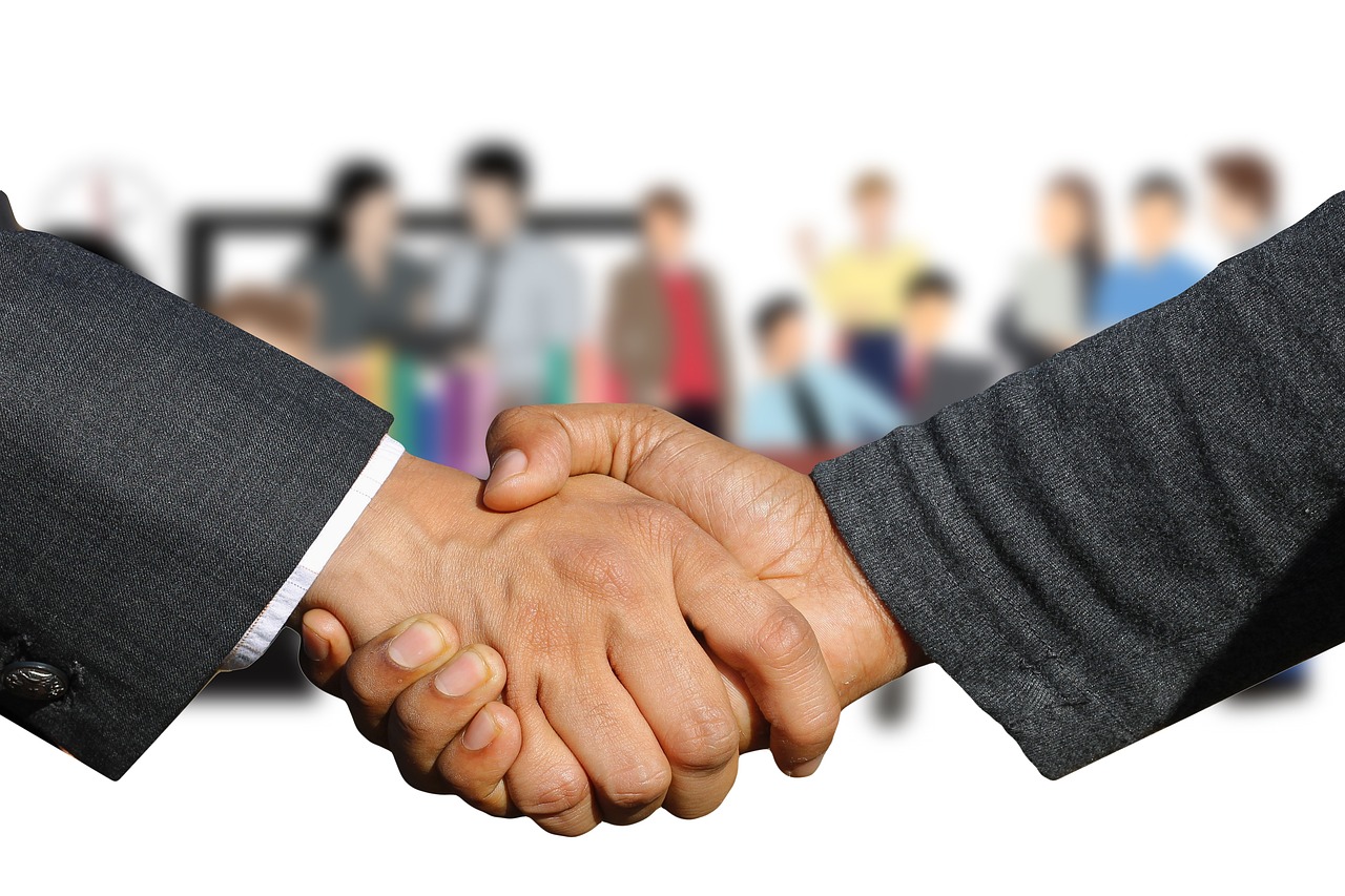 Two professionals shaking hands symbolizing an employer contribution agreement.
