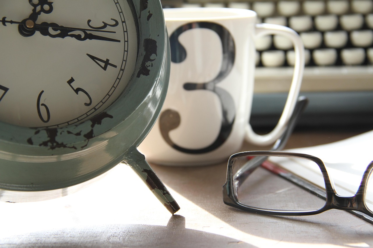 A modern desk featuring a physical calendar and a clock, symbolizing the waiting period for policy rules.