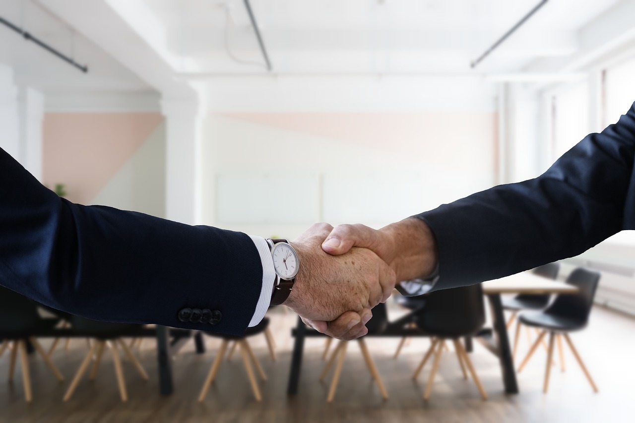 A professional handshake over a desk representing a successful debt settlement negotiation.