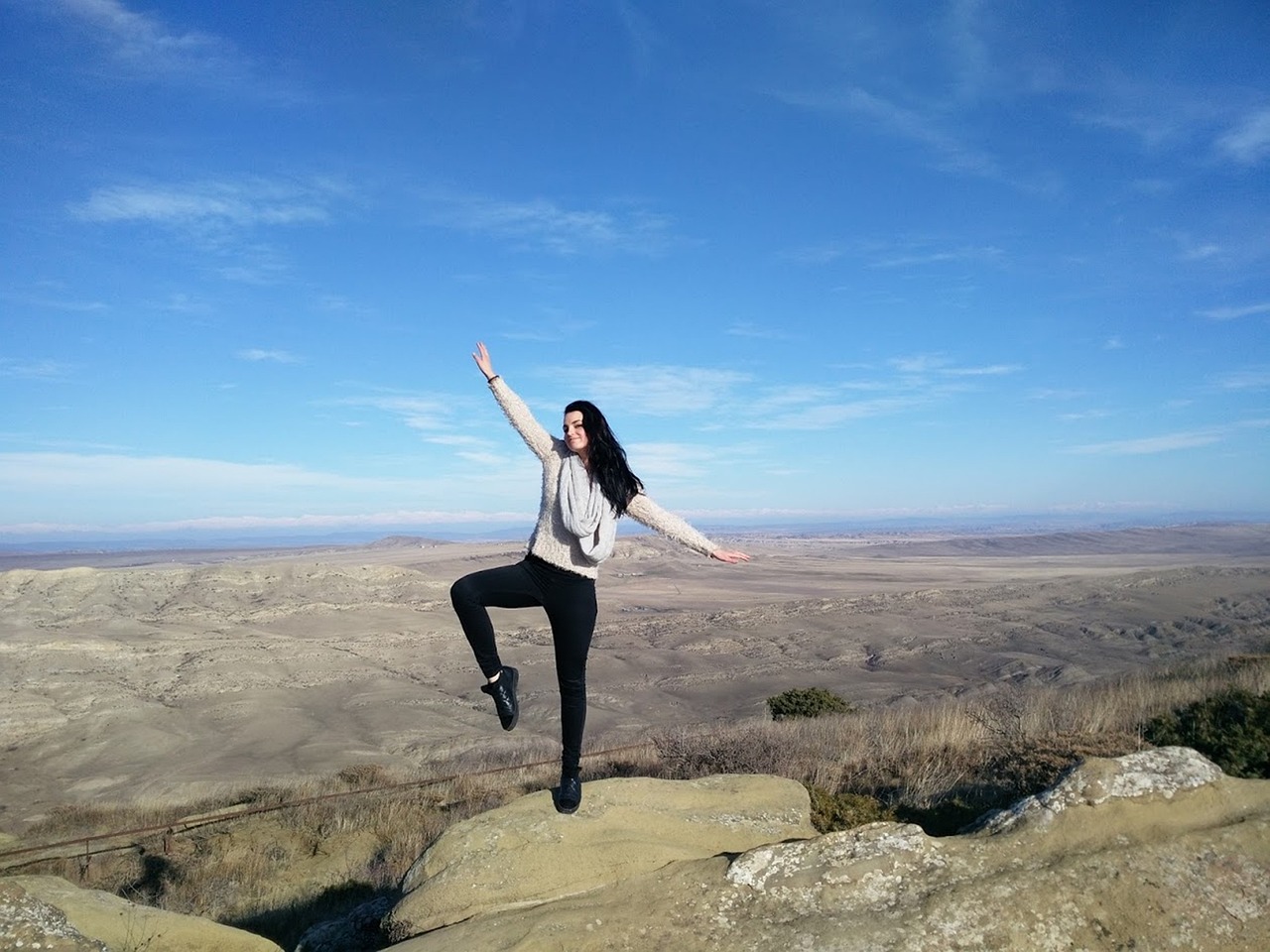A person sitting peacefully looking at a vast mountain range, representing financial freedom.