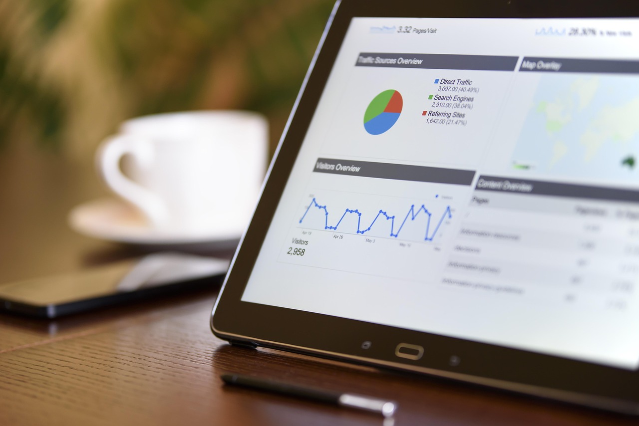 Hand holding a tablet displaying colorful financial charts and credit score data.