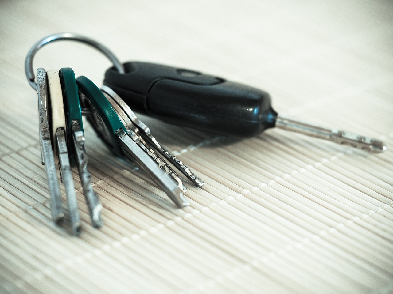 House keys resting on a calculator on a wooden table, symbolizing mortgage management.
