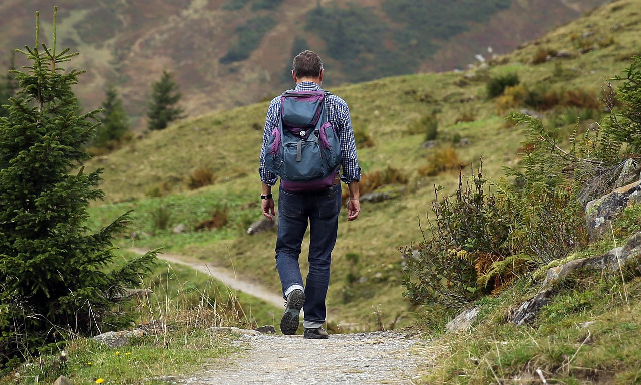 A pair of hiking boots and a backpack overlooking a vast valley.