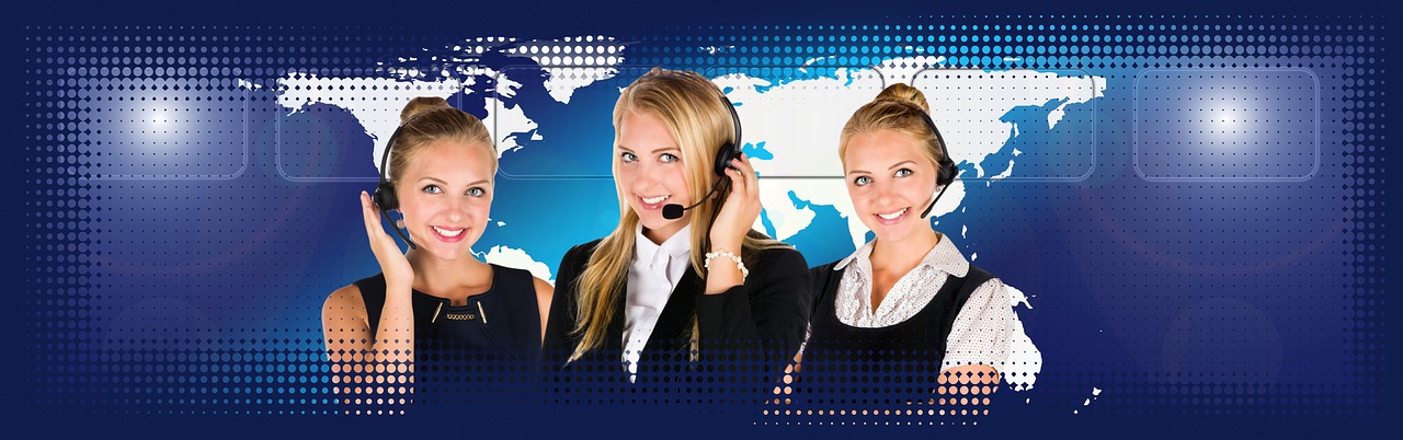 A customer service representative with a headset working at a computer in a clean office environment.
