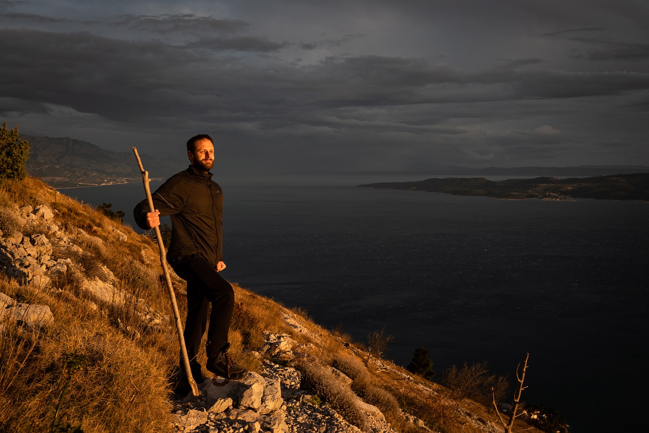 A person looking out over a mountain horizon at sunrise, symbolizing financial freedom and peace of mind.