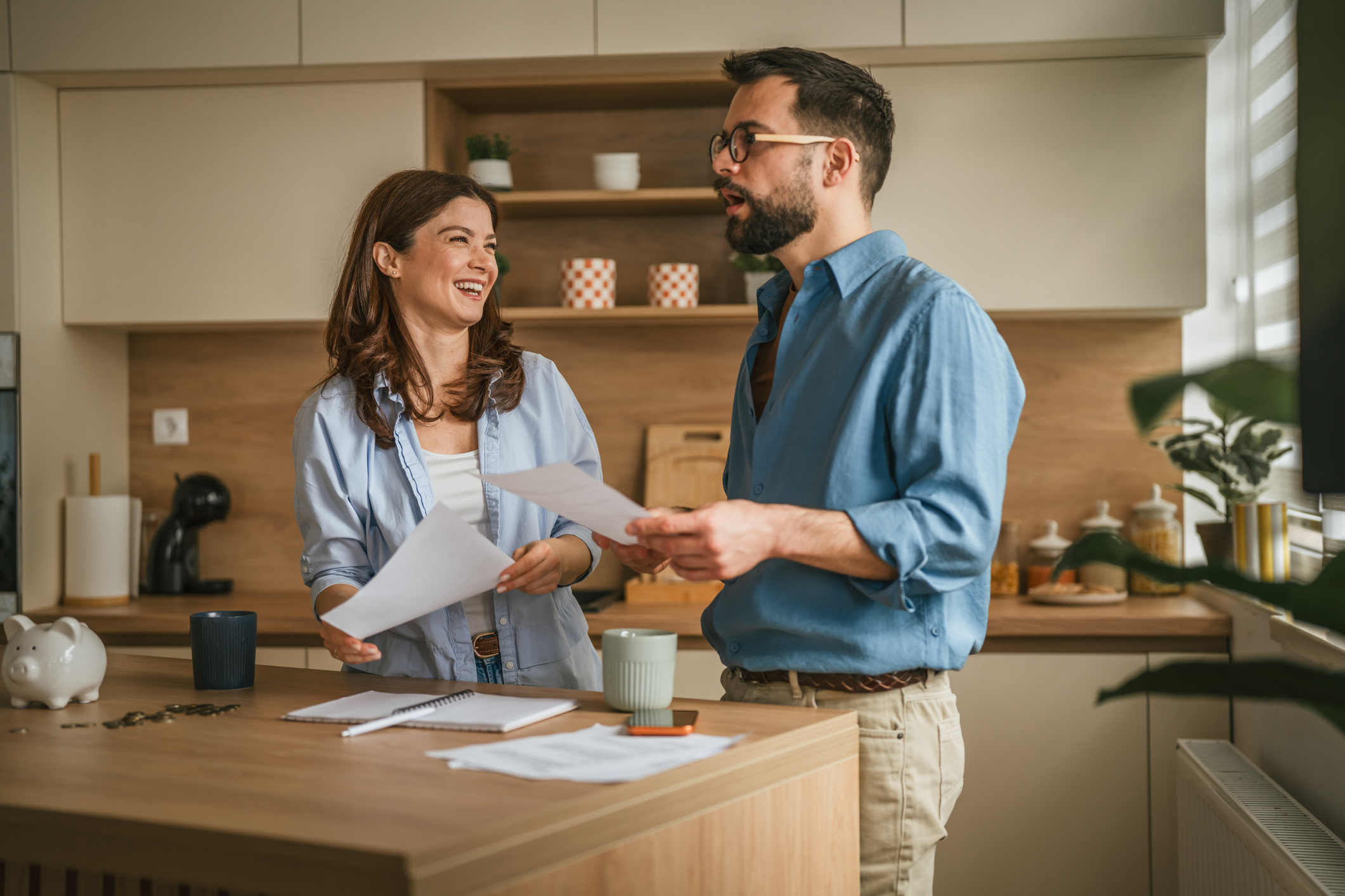A young couple reviewing digital financial statements on a laptop together in a domestic setting.