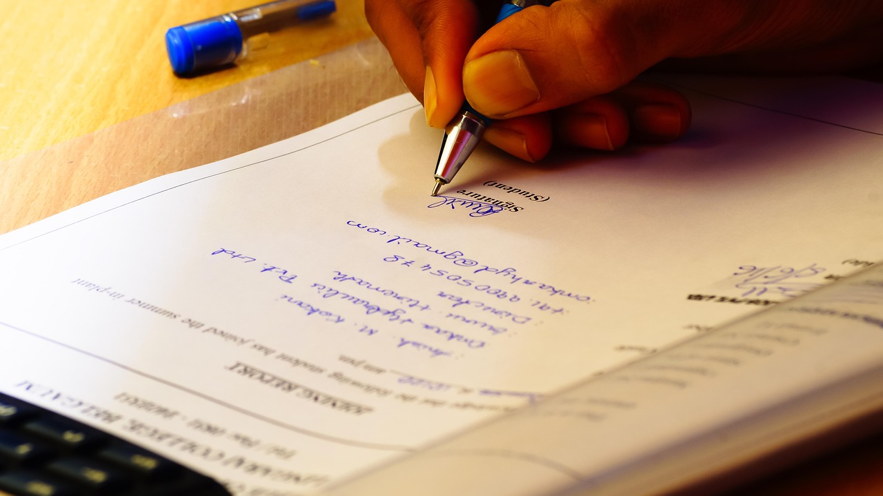 A close-up of a fountain pen signing the bottom of a legal document.