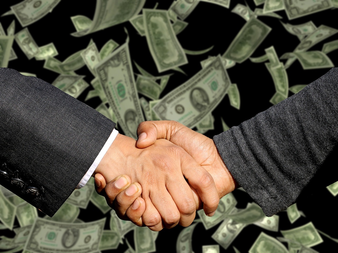 A professional handshake over a desk representing a successful debt validation or agreement.